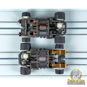 Two black chassis for model train cars, showing motor and wheel mounts for Tyco