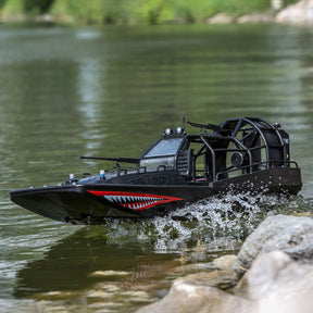 Black remote-controlled air boat moving through calm water near rocks for Pro Boat PRB08034