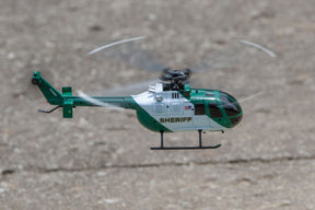 Green and white remote-controlled helicopter flying outdoors for Rage R/C RGR6052