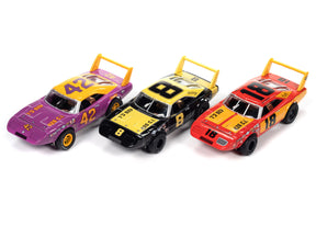 Three vintage slot cars: purple, black, and red race cars for Auto World SCM111