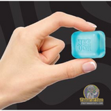Hand holding a small, light blue, square toy block for Schylling TSNCBND