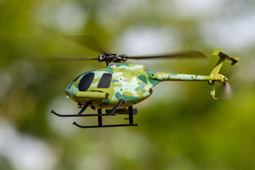 Green and tan remote-controlled helicopter flying outdoors for Rage R/C RGR6101