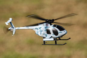 Miniature helicopter flying low over a grassy field for Rage R/C RGR6102