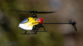 Yellow and red micro helicopter flying outdoors against a blurred background for Rage R/C RGR6001