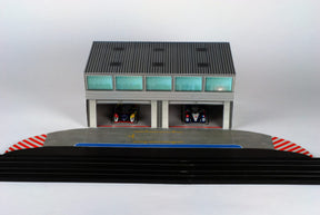 Scale pit building with two garage bays and a track section for AFX RaceMaster 1070