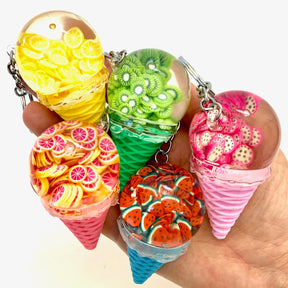 Colorful, fruit-themed key charms resembling ice cream floats on a hand for Bcmini 12068, front view