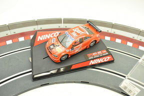 Orange slot car on black base with "Opel Astra V8 Coupe" text for Ninco 50268