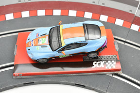 Blue and orange Aston Martin Vantage race car on a track section for SCX A10116X3U0