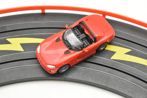Red toy car on a black and orange race track for Tyco B15043