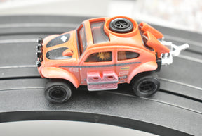 Orange VW Beetle toy car with dirt effect on a track for Auto World SC011