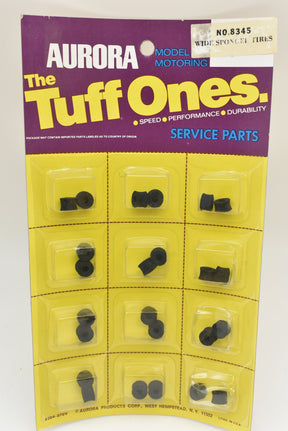 Assortment of small, black, sponge-like tires in a yellow plastic card for Aurora Model Motoring 1 card of 12/Pk