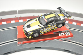 Yellow and black Mercedes SLS GT3 race car on a track base for SCX A10154X3U0