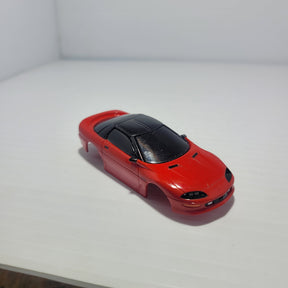 Red Camaro Z-28 body shell on a white surface