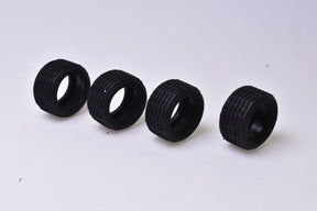 Four black slot car tires, 20x11 Super-Racing size, laid out for NINCO Slot Cars 70140