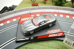Silver model car on a track base with green scenery for Ninco 50233
