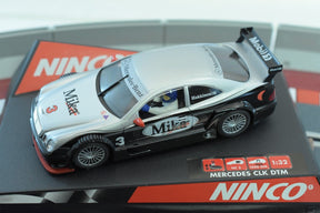Silver Mercedes CLK DTM slot car with "Milka" branding on a display base for REH Ninco 50265