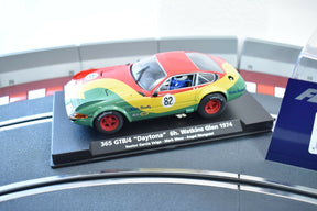 Red, yellow, and green 1974 race car model on a display base for Fly Car 88190