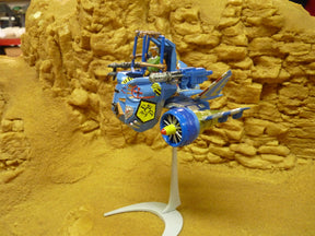 Blue and yellow robot vehicle model on a yellow, textured surface for Robogear 6005