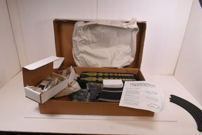 Race track plans and accessories in an open cardboard box for SCX/Scalextric SPA300
