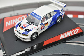 White and blue BMW M3 GTR slot car on a black track section for REH Ninco 50271