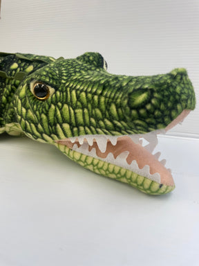 Green stuffed crocodile toy with an open mouth, resting on a white surface for Real Planet CE109MG