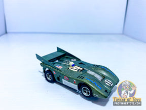 Green slot car, McLaren XLR style, displayed on white surface for Aurora AFXCUST1971