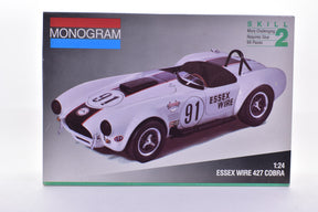 Model kit box art showing a white 1:24 scale Essex Wire Cobra race car for Monogram 2944