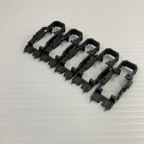 Five black chassis frames for vehicle repair, laid out on white for Tyco H4011