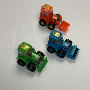 Three toy construction vehicles: green, orange, and blue dump trucks for Nassau Candy 33027