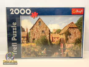 Puzzle box showing a quaint, rustic village scene with buildings by a pond for Trefl TRF27078