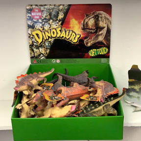 Assortment of soft, toy dinosaur figures in a green display box for Schylling IMX49431