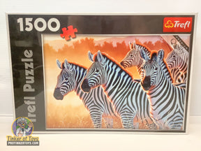 Three zebras puzzle box art showing zebras in a savanna setting for Trefl TRF26129