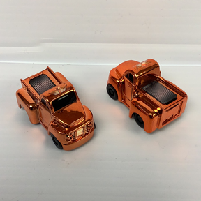 Two small, metallic orange toy trucks with visible internal details for California Creations 20553, front view