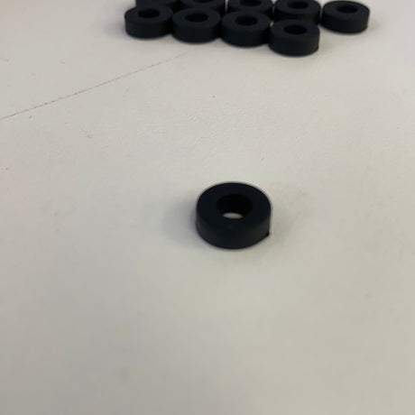 Black slot car front tires arranged on a white surface for Auto World CP7910