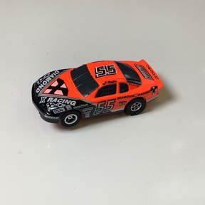 Orange and black slot car race car, number 55, on a white surface for Aurora / AFX / Tomy 9870