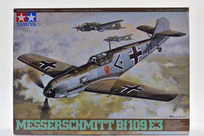 Model kit box art: Messerschmitt Bf 109 E3 aircraft in flight for Tamiya 61050