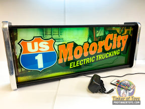 Neon sign displaying "US 1 Motor City Electric Trucking." for QEC