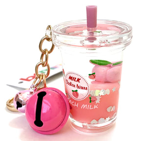 Pink key charm next to a peach-flavored milk drink with a straw for BCmini 12065