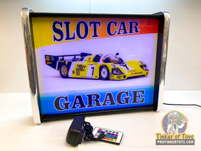 Illuminated sign reading "SLOT CAR GARAGE" with race cars displayed for QEC