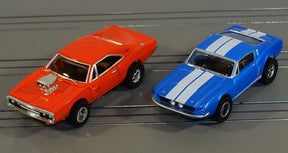Red and blue slot cars on a gray surface for Auto World SRS335SC
